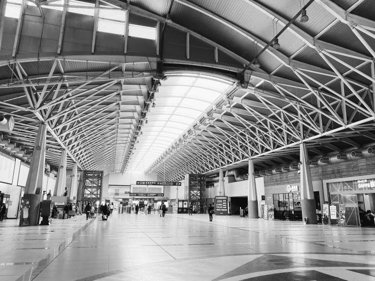 people walking through an air port terminal with metal ceilings