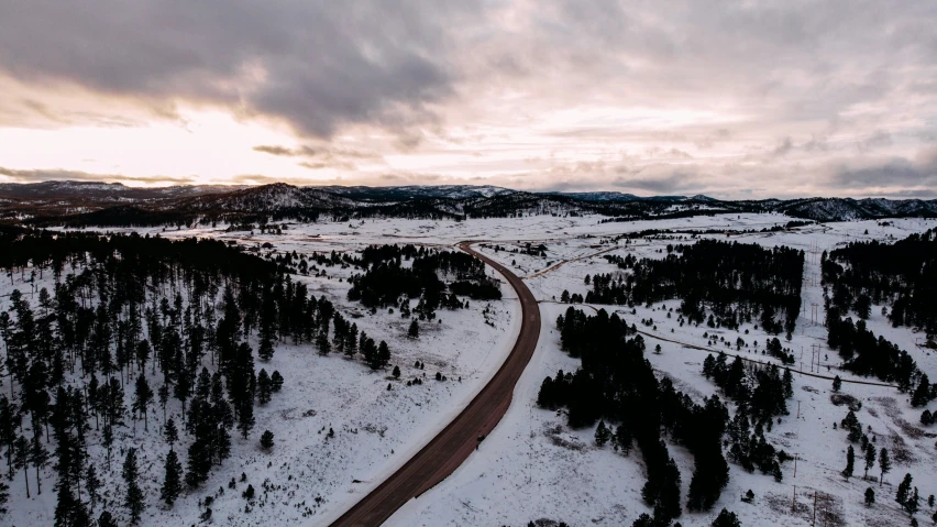 a snow covered landscape with some trees on one side