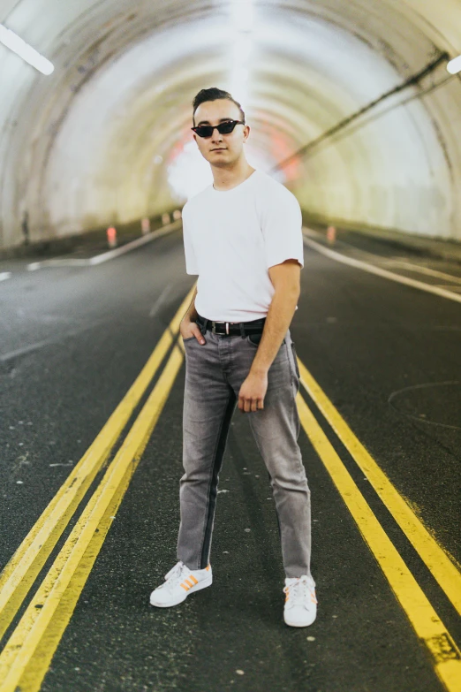 man in a white shirt standing in a tunnel