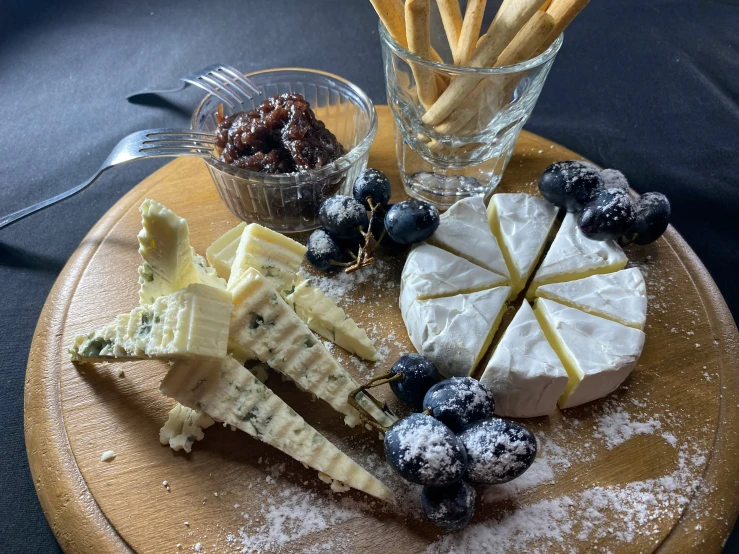 a wooden tray with many types of cheese on it