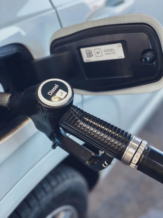 a gas pump connected to a car at a filling point