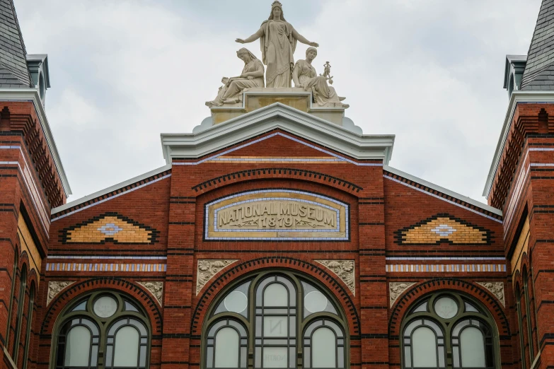 a brick building with an architectural statue atop