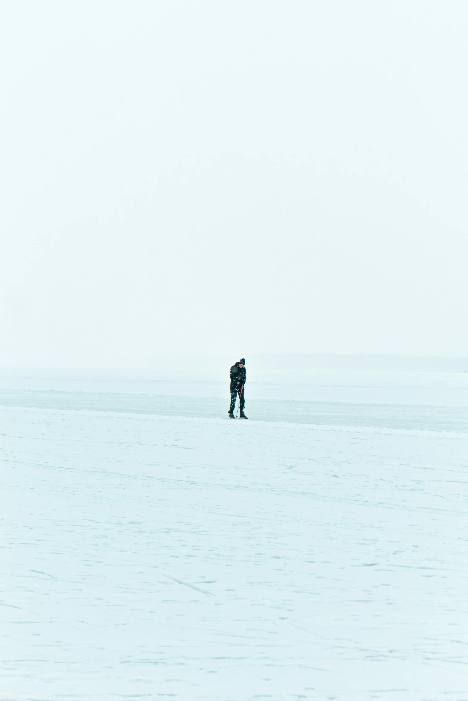 a couple standing on the snow looking at soing