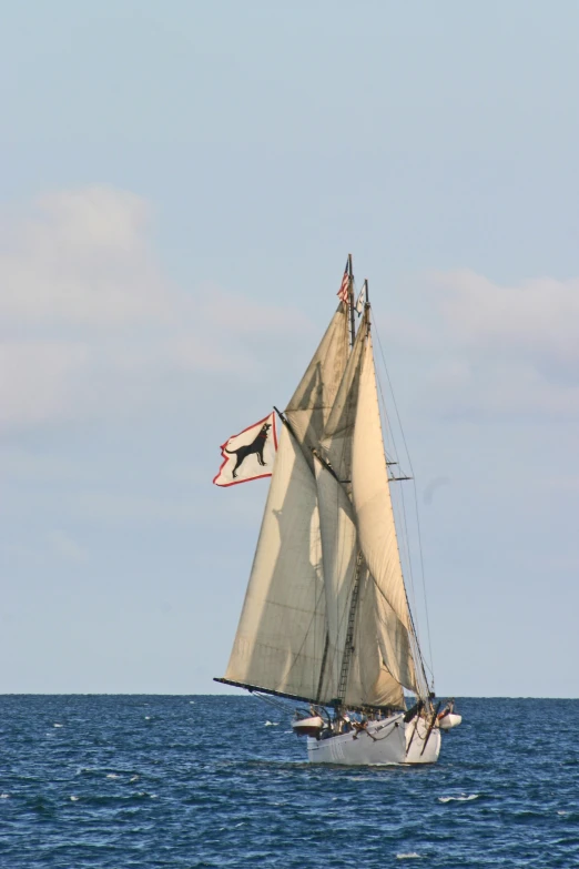 a sailboat that is flying its sails on the ocean