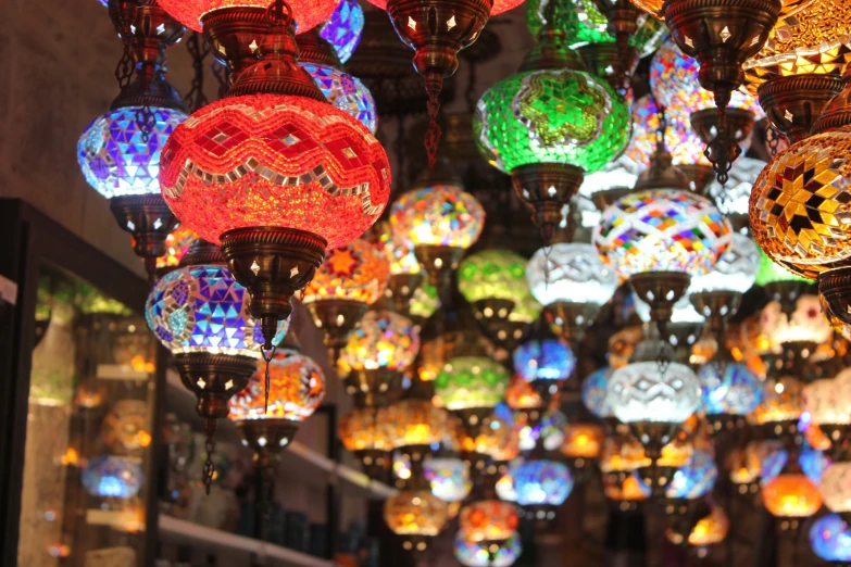 many colored lamps in different colors hanging from the ceiling