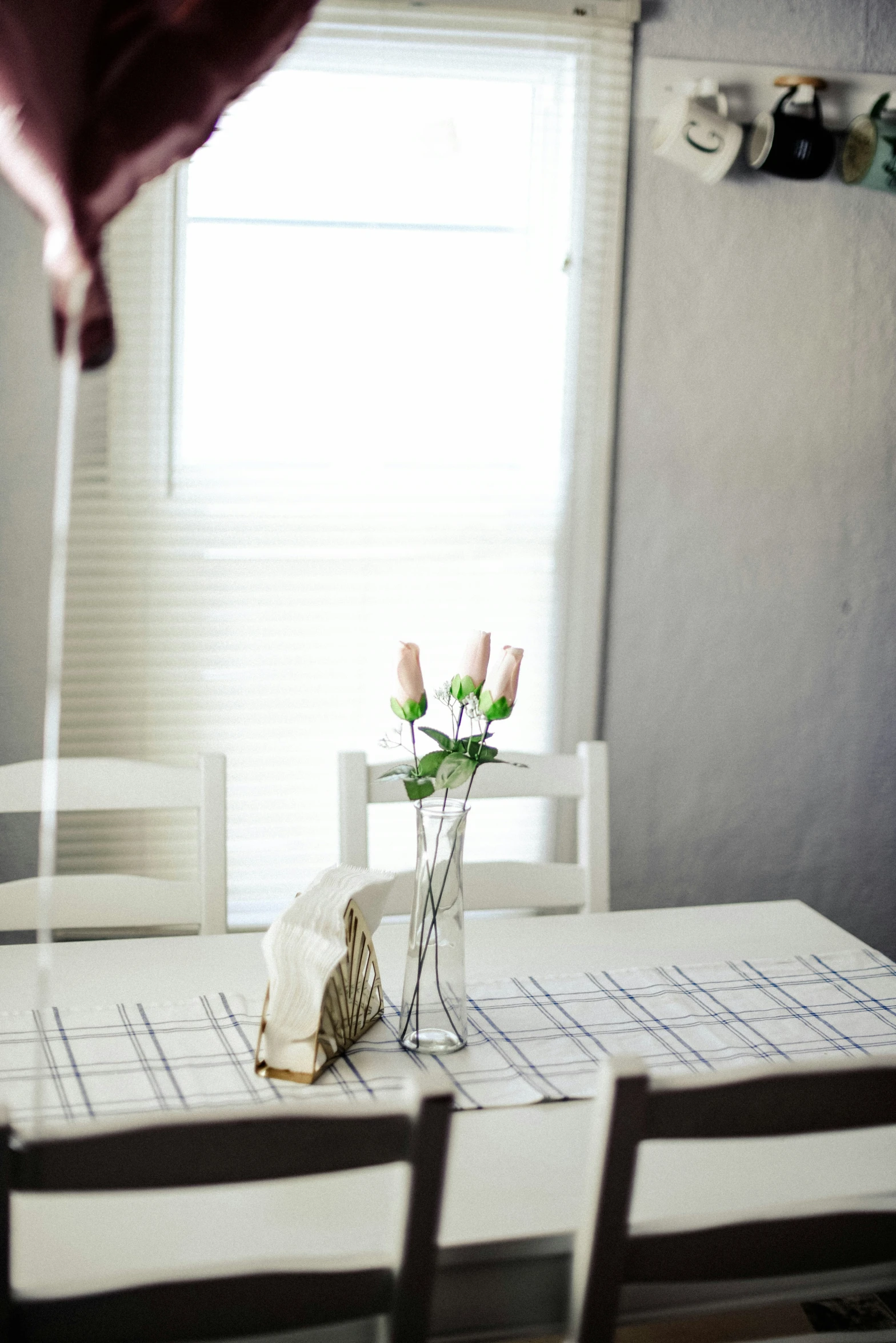 a table with flowers in a vase next to two chairs