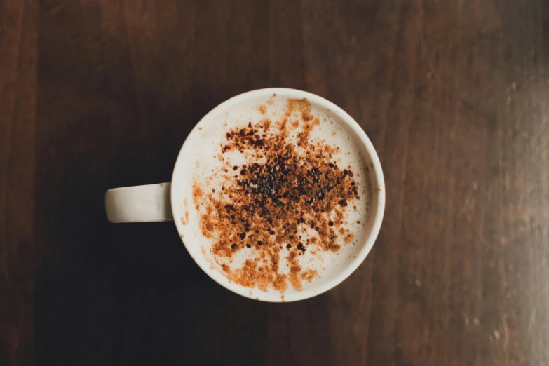 cappuccino with coffee and cinnamon sprinkles in a white cup