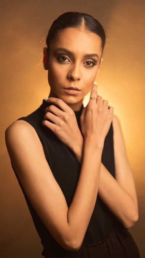 a woman wearing a black dress poses for the camera