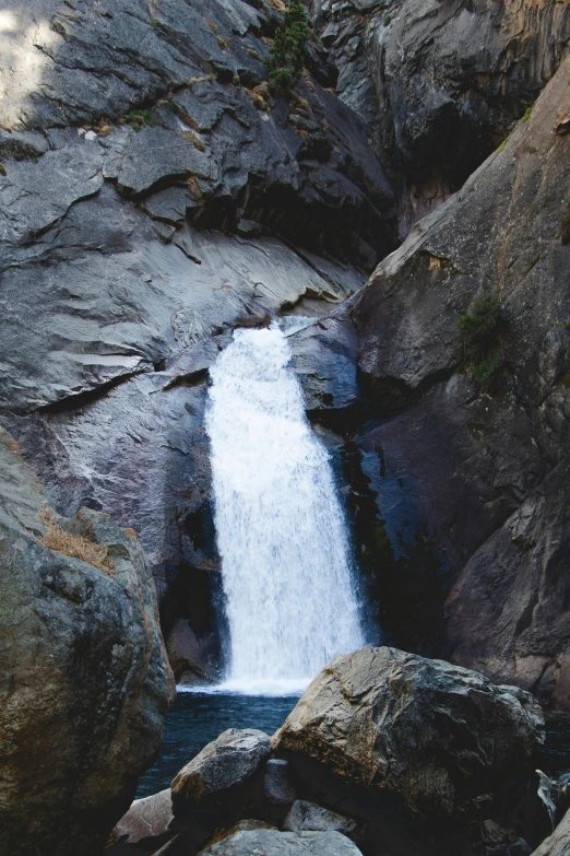 an outdoor area features a rock waterfall and large boulders