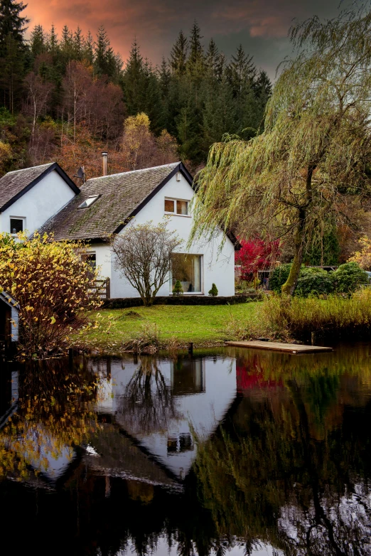 a beautiful country house sits next to a body of water