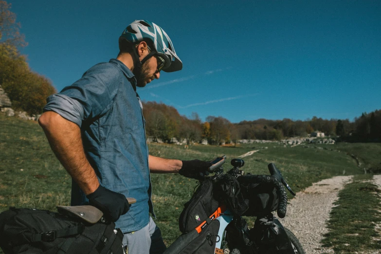 a man standing in a field next to his bike