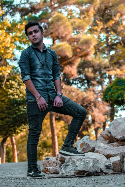 a young man is standing on rocks by himself