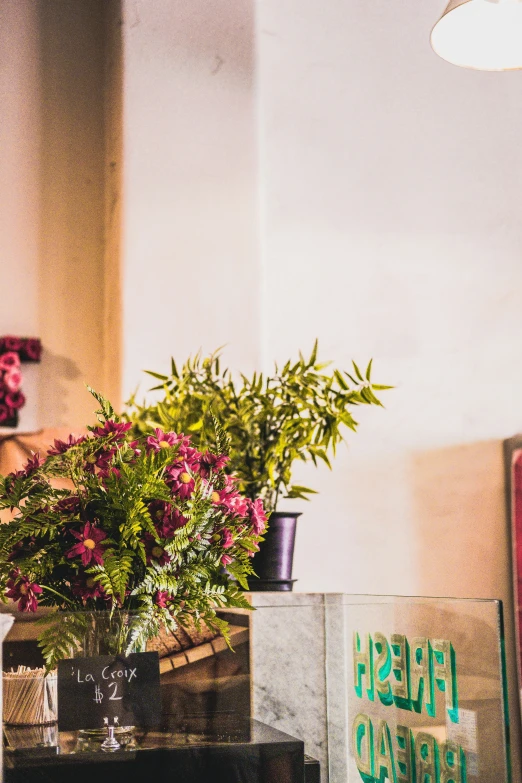 flowers and pictures are arranged beside a lamp