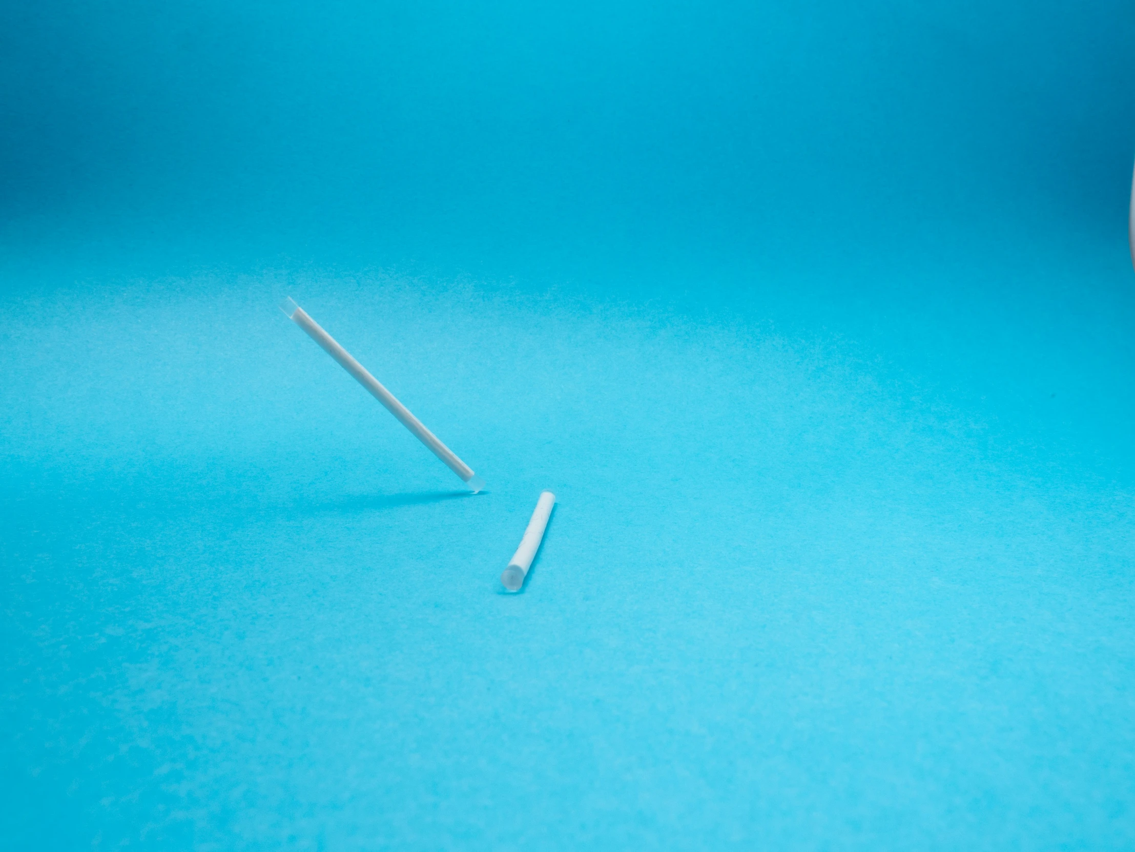 a pair of tooth brushes laying on a blue table