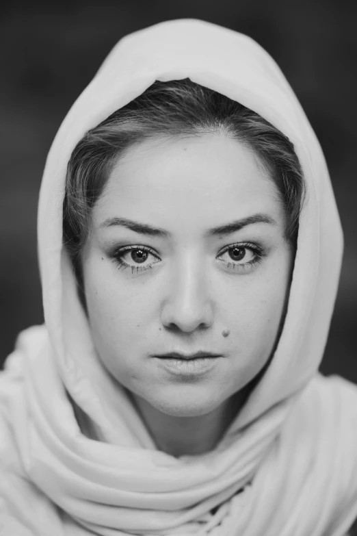 a woman with hood and face is looking at the camera