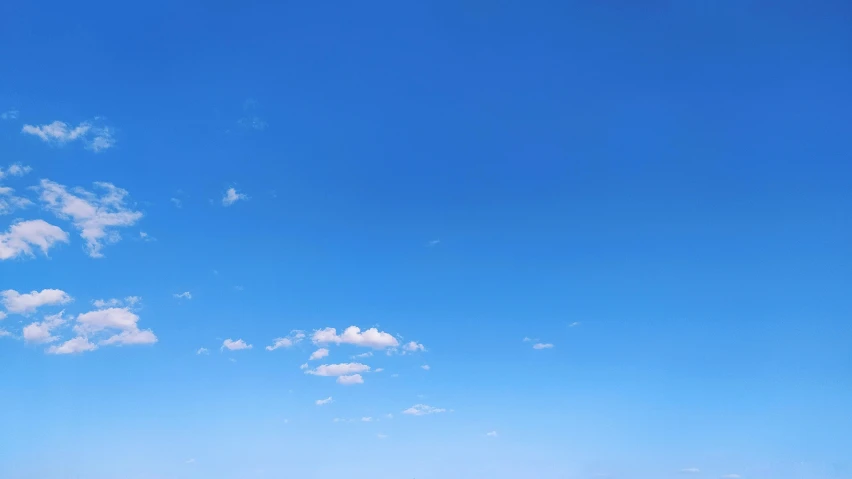 a plane flying over the ocean on a sunny day