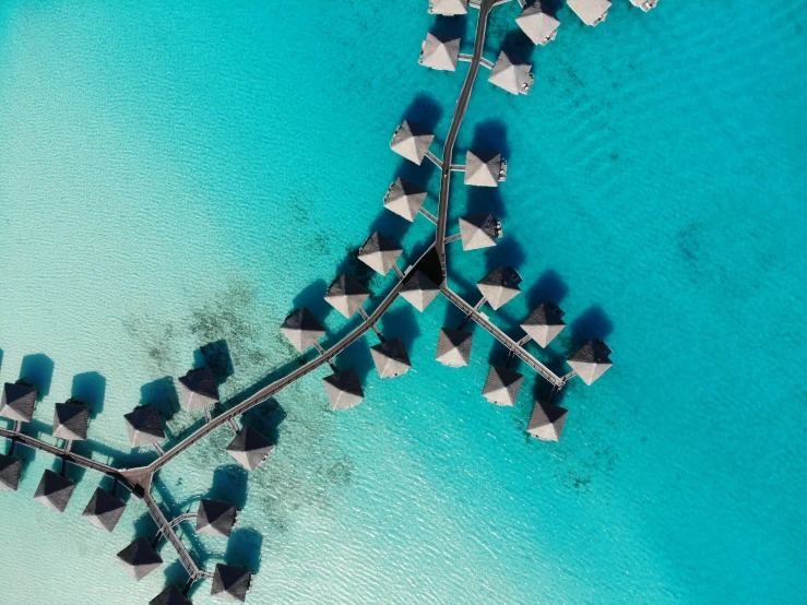 the view from a plane of a group of watercrafts on a turquoise ocean