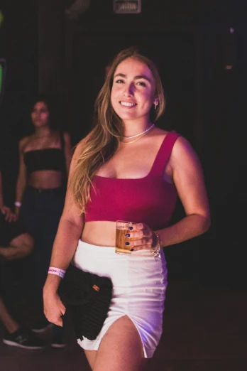 a young woman wearing a red crop top and white shorts