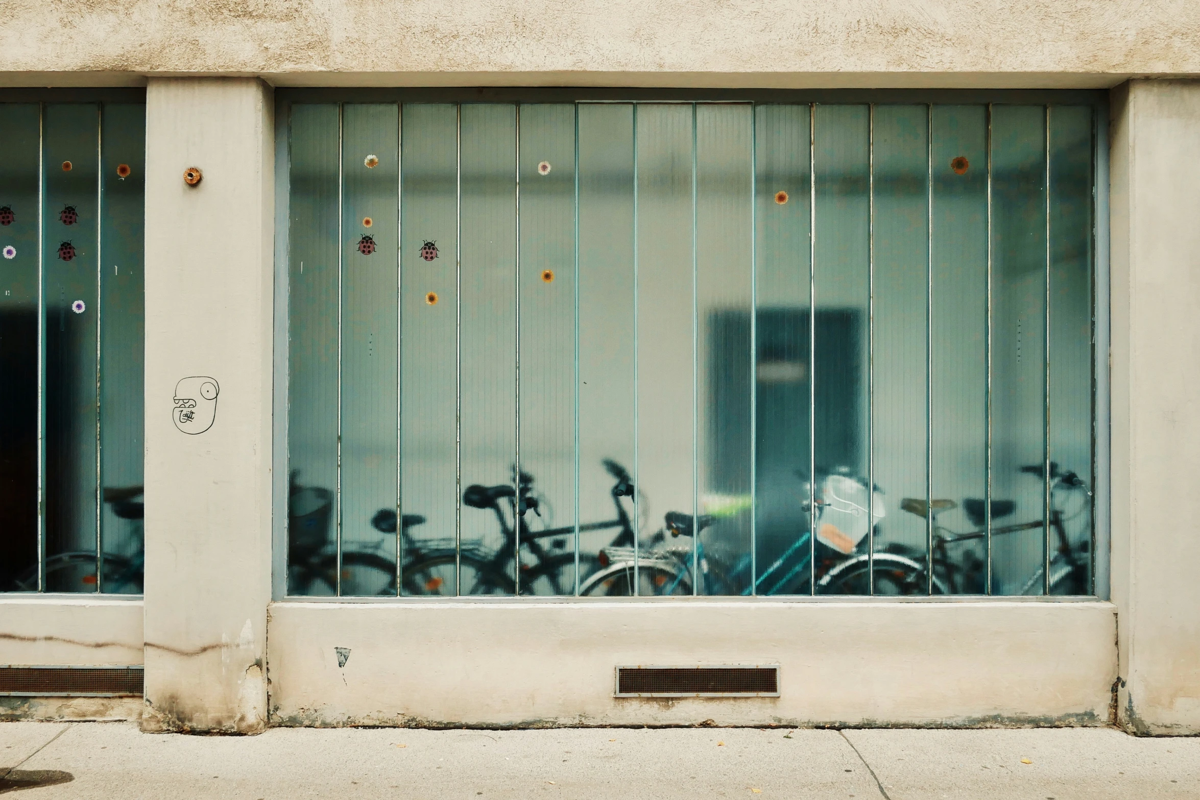 bicycle are behind bars with their reflection in the glass