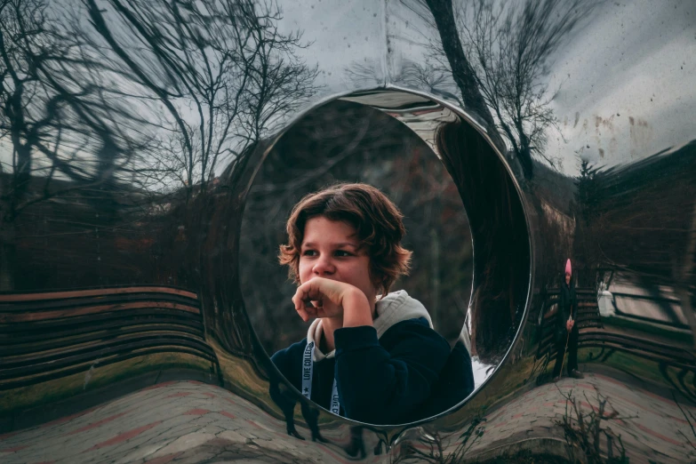 a  poses in front of an interesting mirror