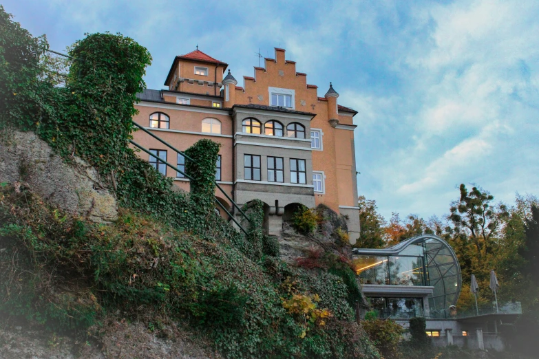 a tall brown building with lots of windows on top of a mountain