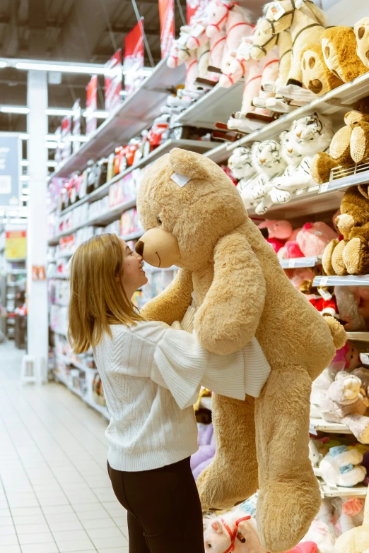 a woman holding up a large teddy bear