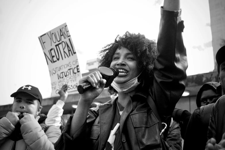 a group of protestors holding signs and microphones