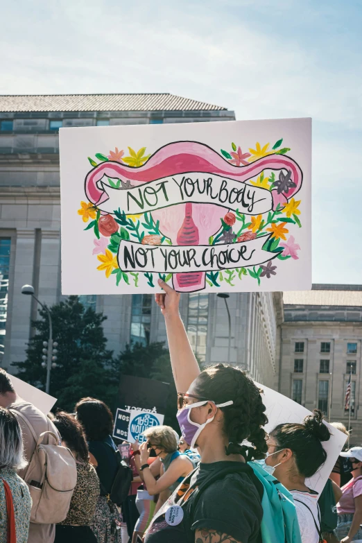 many people are protesting outside holding up a sign