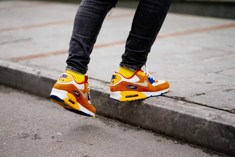 a person with yellow and blue shoes on the pavement