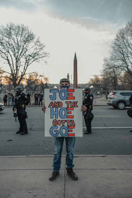 a man holding up a sign at the washington monument