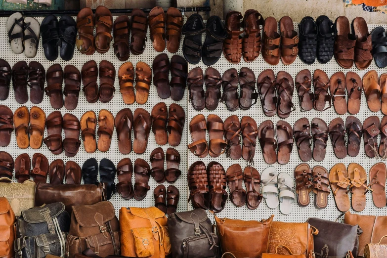 there are rows of shoes on display on the wall