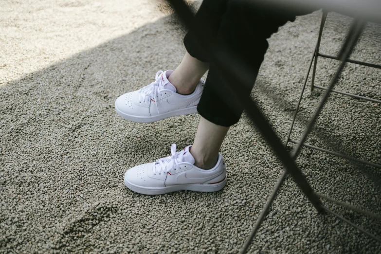 a person with pink shoes sits on a chair