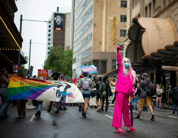 a woman dressed in pink holding up her hand