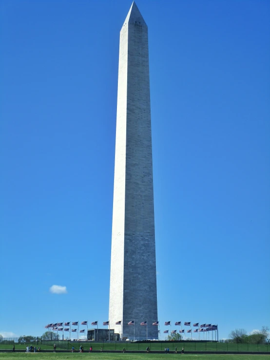 a very tall obelisk stands tall against a blue sky