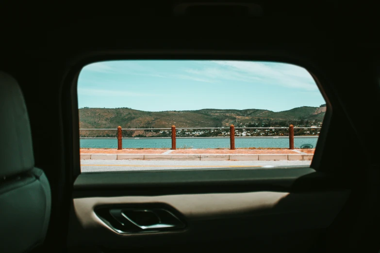 the window view from inside a car showing a lake