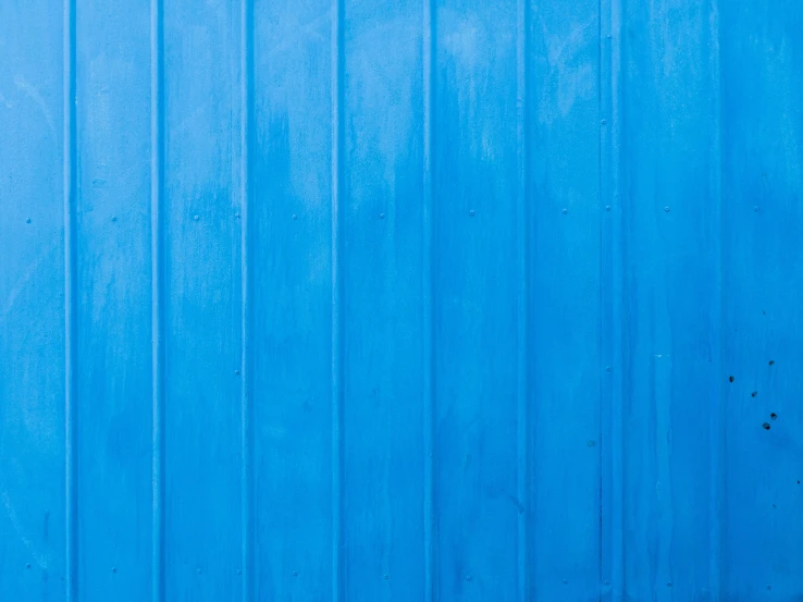 two people are walking by an empty blue wall