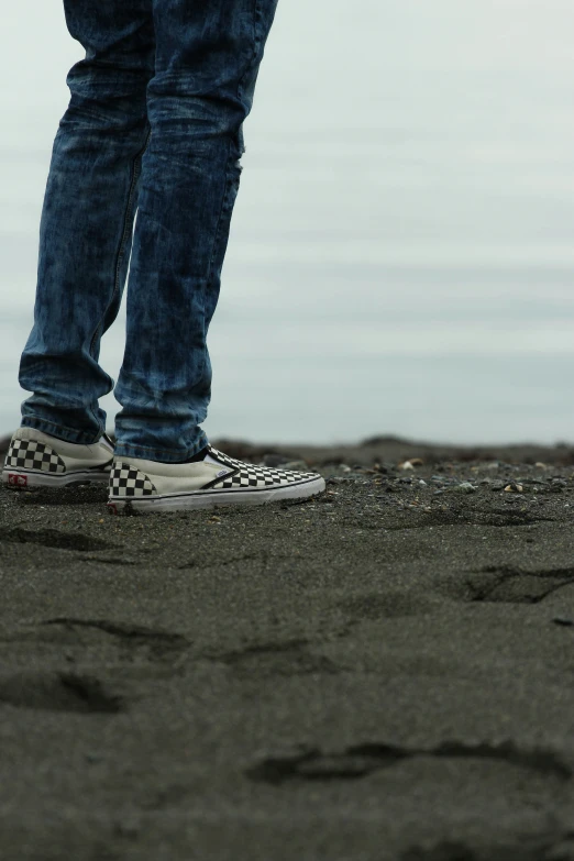 man standing in the sand with his foot up