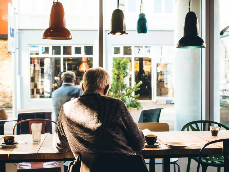 an elderly woman sitting at a table in a restaurant