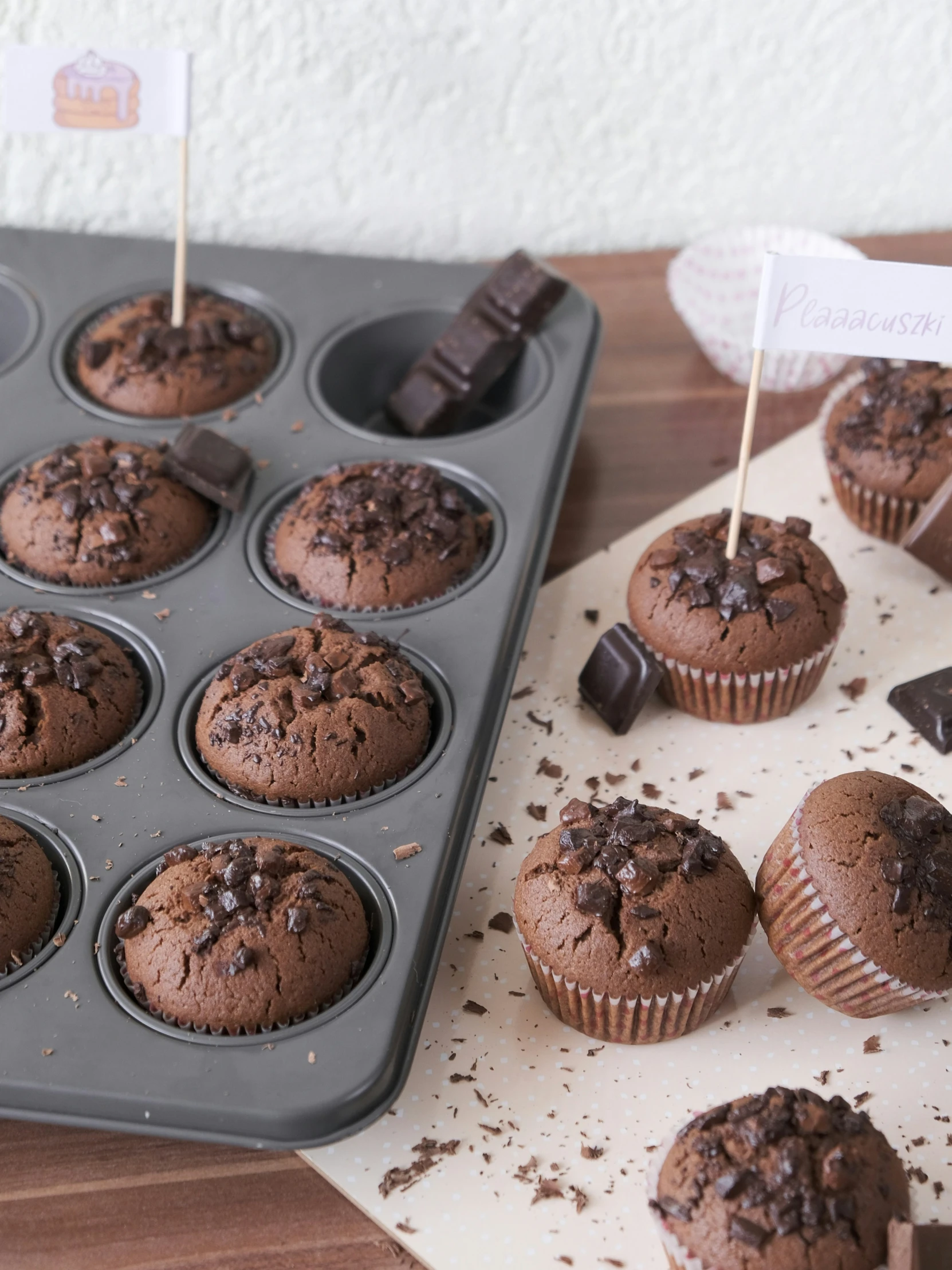 the tray of chocolate cupcakes has a flag sticking from it