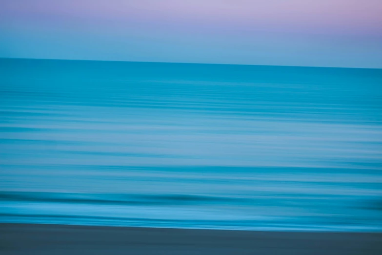 an airplane flies low over the ocean at sunset