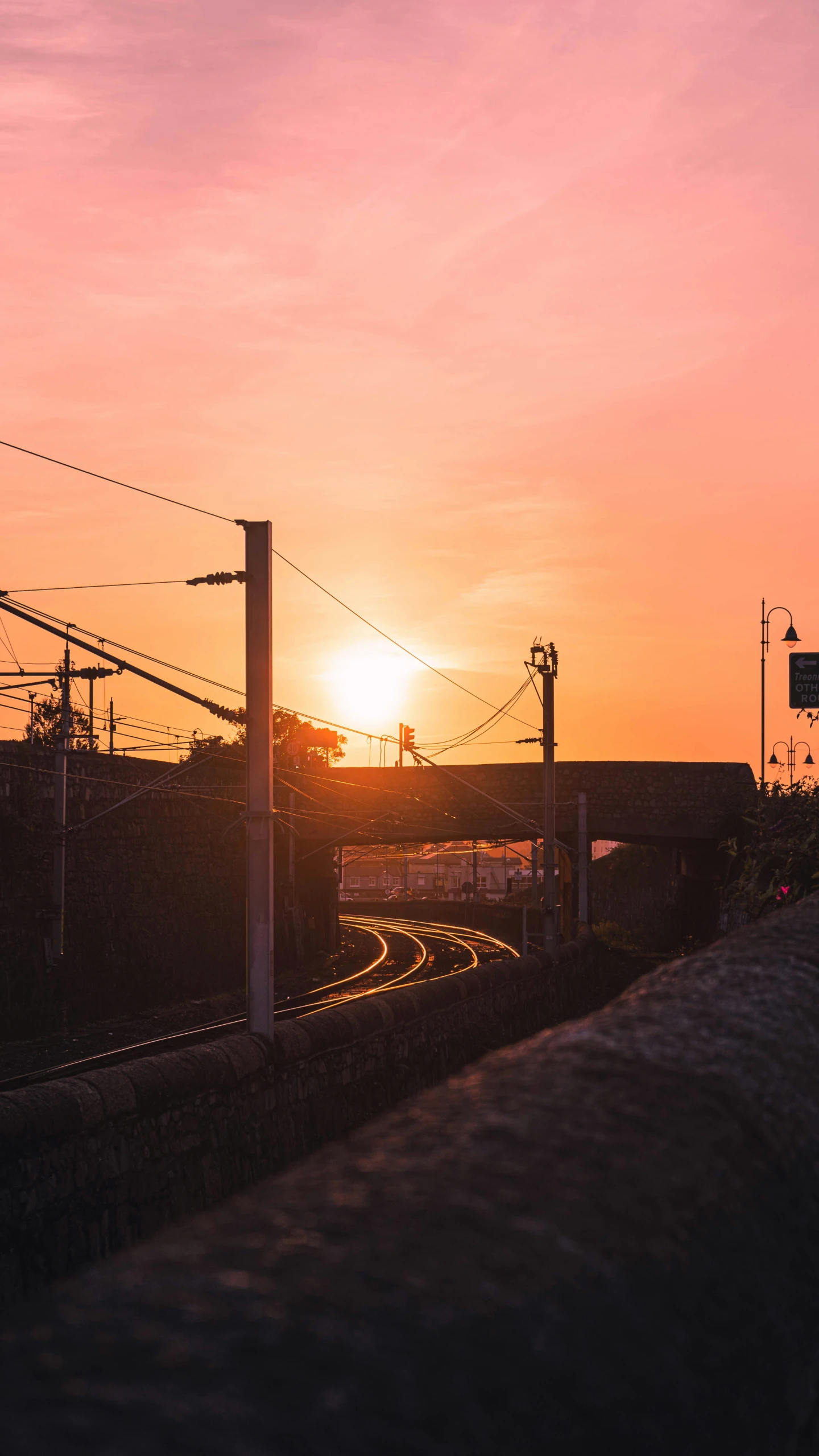 the sun is setting behind an electric pole