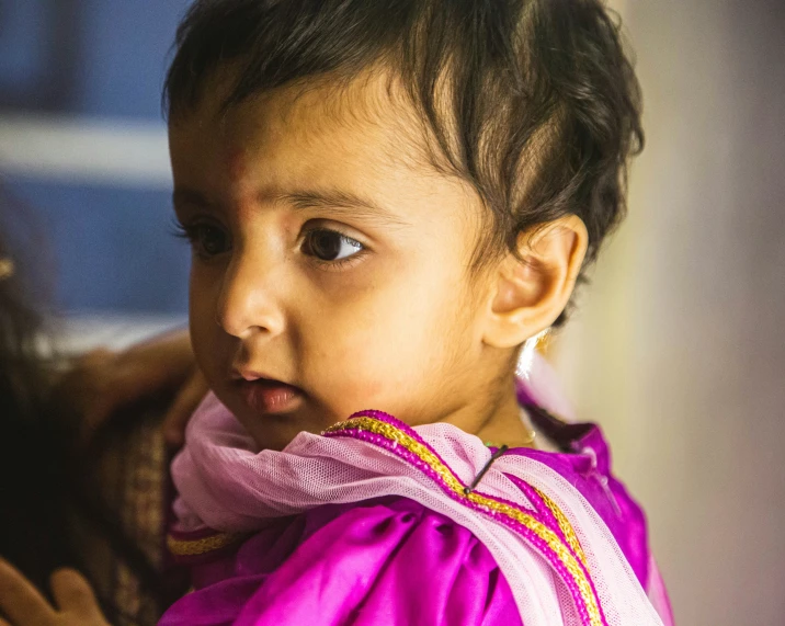 a little girl that is wearing a purple shirt