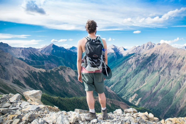 man looking at the view from the top of the mountains