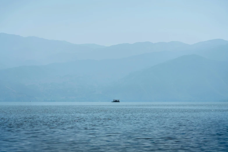 two large boats in the water near mountains