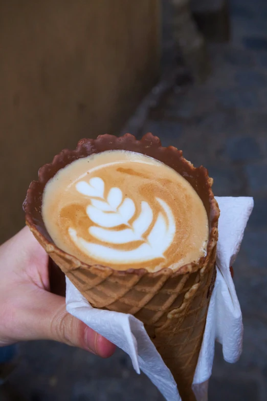 the person is holding the ice cream in the cone