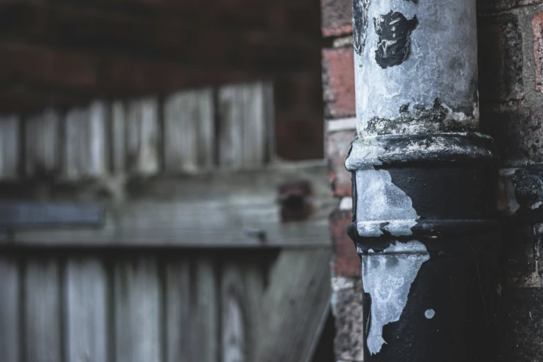 the paint chipped on a pole and fence is brown