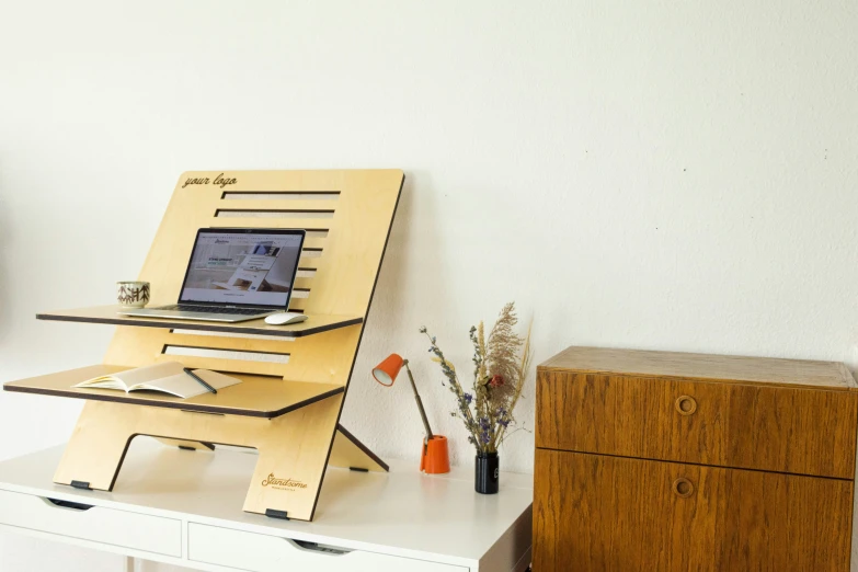 there is a laptop on a desk and some vases and flowers