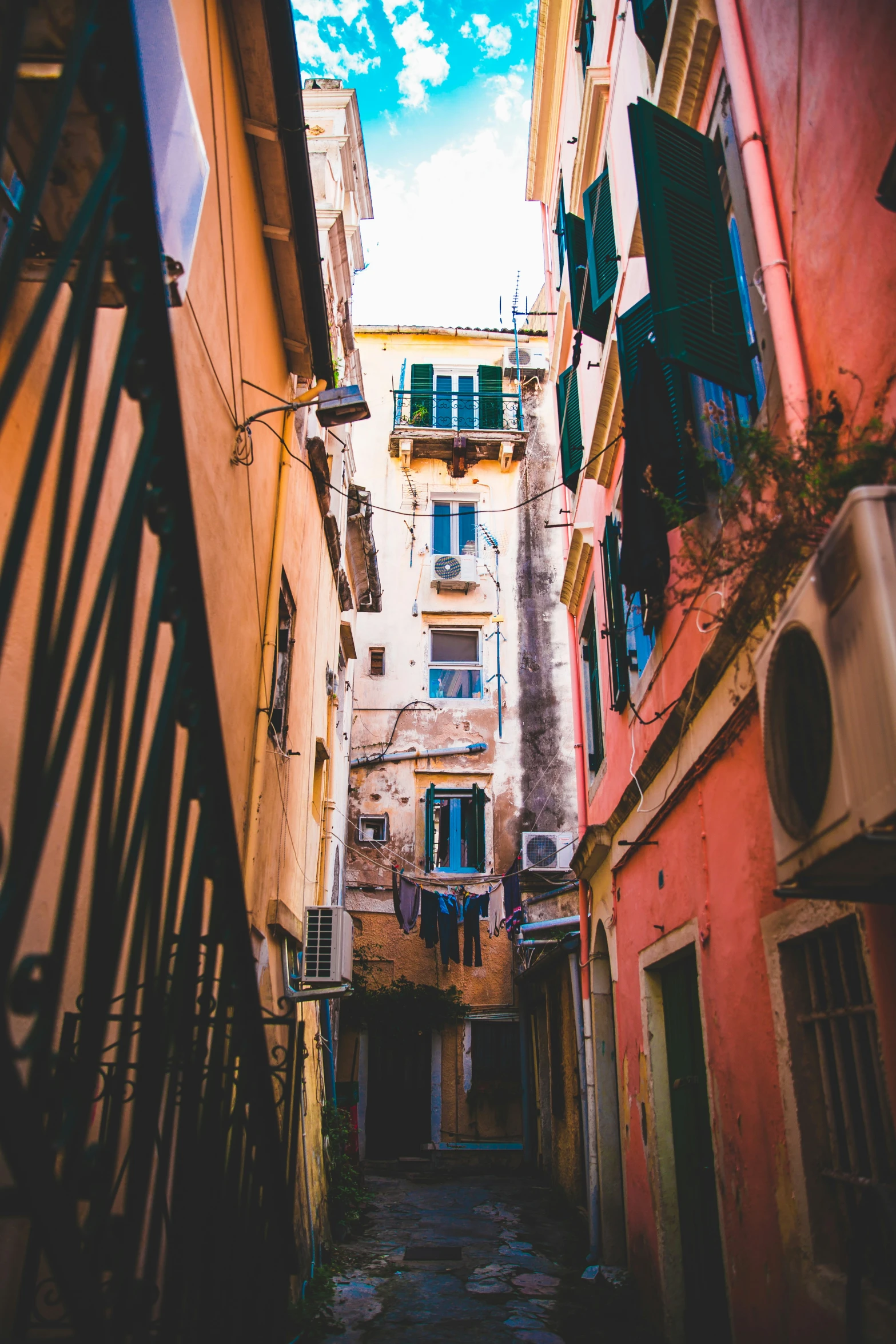 the view of a narrow alleyway on a sunny day