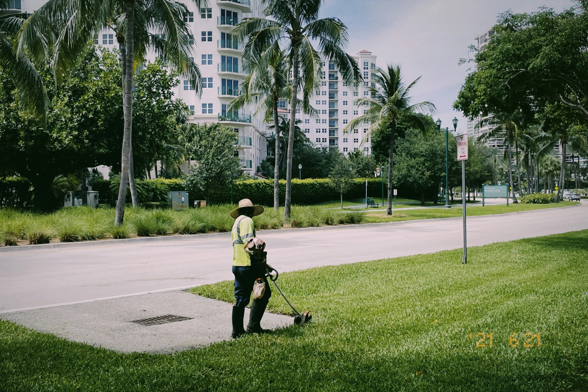 a man using an electric mower down the sidewalk