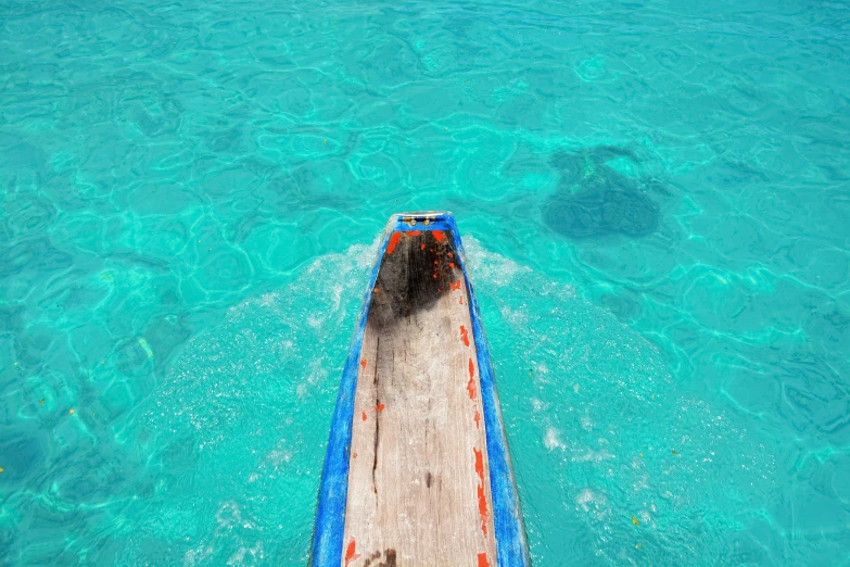 a boat floating in clear blue water on the ocean